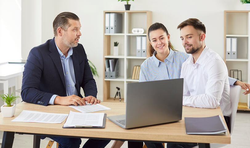 Young couple talking to an estate agent.