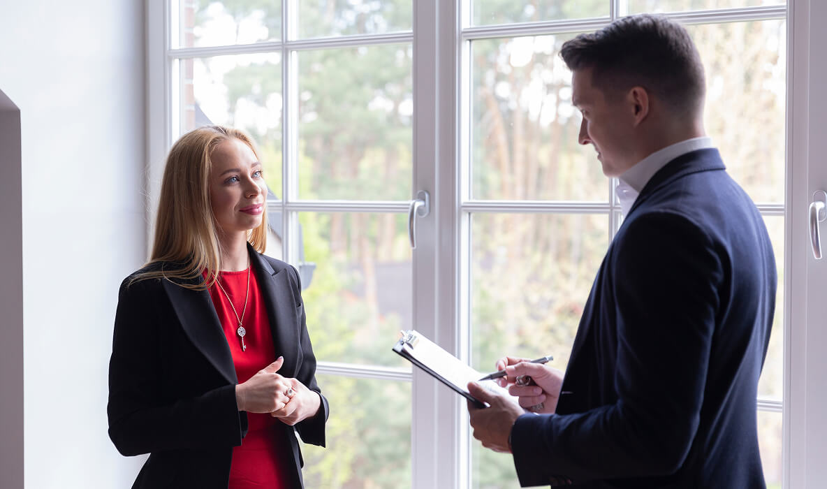 Estate agent speaking with potential client during a property valuation meeting.