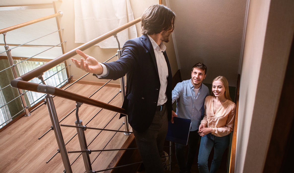 Estate agent showing a property to a couple of potential buyers during a home viewing.