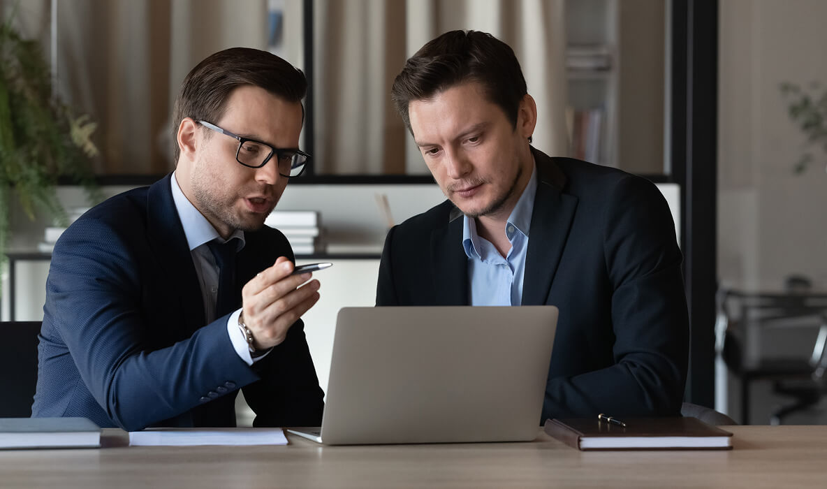 Estate agents reviewing tenant application on a laptop.