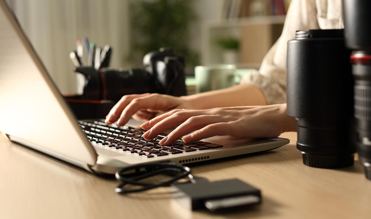 Estate agent working on a laptop keyboard in office setting